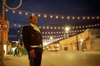 A musician stands on the street that leads to the Paso del Norte International Bridge in Mexico