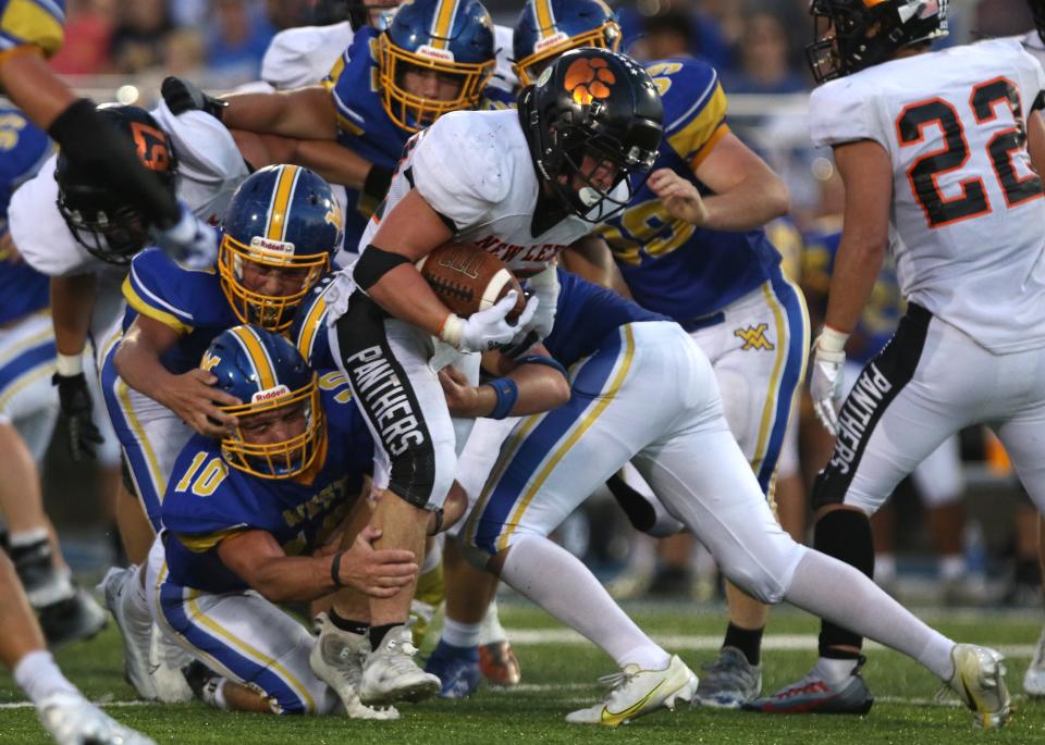 A host of West Muskingum defenders tackle New Lexington's Hunter Rose.