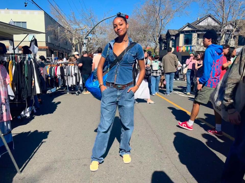 Jordyn Milan poses at World’s Worst Expo in midtown Sacramento. FIT CHECK: Milan is wearing thrifted Wrangler jeans, her sister’s belt, Adidas Gazelle shoes, a Baggu bag and an Ikea bag for all her items from the expo. Hanh Truong/htruong@sacbee.com