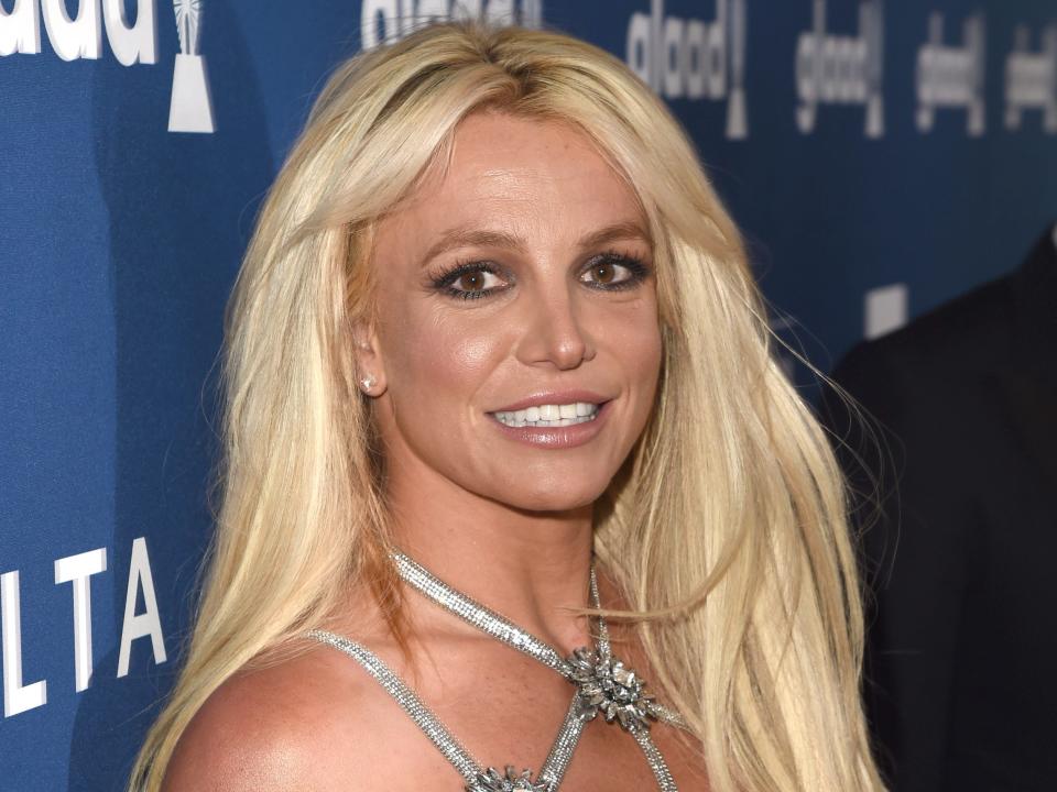 Britney Spears wearing a silver strappy dress on the GLAAD Awards red carpet.