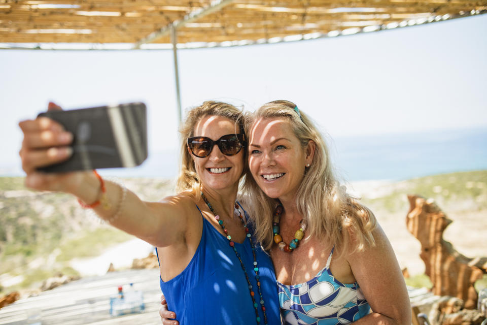 Two friends on holiday, taking a selfie under the gazebo.