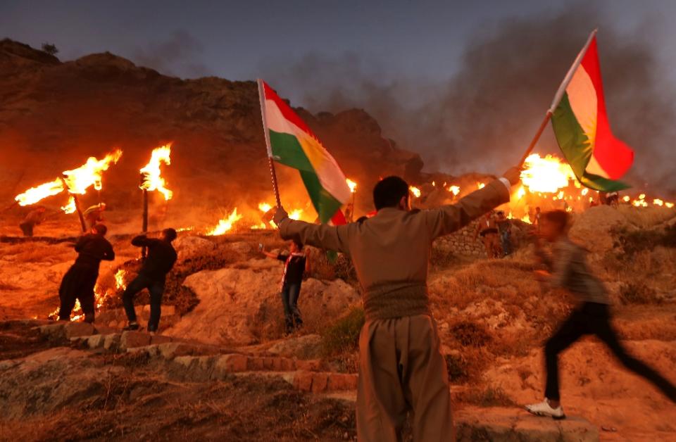 <p>Iraqi Kurds wave Kurdish flags and hold burning torches as they walk up a mountain during a gathering to show support for the upcoming independence referendum and encourage people to vote in the town of Akra, some 300 miles north of Baghdad on Sept. 10, 2017. Iraq’s autonomous Kurdish region will hold a historic referendum on statehood in Sept. 25, 2017, despite opposition to independence from Baghdad and possibly beyond. (Photo: Safin Hamed/AFP/Getty Images) </p>