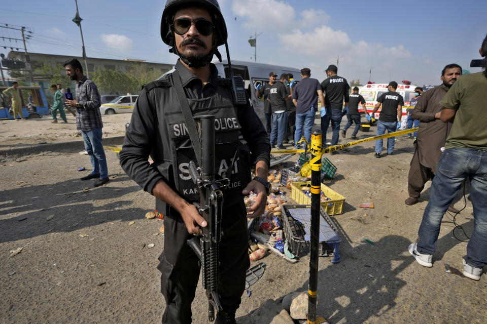 CORRECTS DATE - A police officer stands guard at the site of a suicide attack in Karachi, Pakistan, Friday, April 19, 2024. Five Japanese nationals traveling in a van narrowly escaped a suicide attack when a suicide bomber detonated his explosive-laden vest near their vehicle in Pakistan's port city of Karachi on Friday, wounding three passers-by, police said. (AP Photo/Fareed Khan)