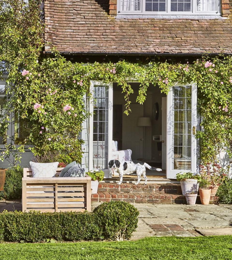 <p>A rose arch running over a garden path or along a patio door frame will give any space an English countryside feel. (It helps to have an <a href="https://www.countryliving.com/life/kids-pets/a33980239/most-popular-dog-breeds-american-kennel-club/" rel="nofollow noopener" target="_blank" data-ylk="slk:adorable dog;elm:context_link;itc:0;sec:content-canvas" class="link ">adorable dog</a> as well!)</p><p><strong><a href="https://www.countryliving.com/gardening/garden-ideas/g32146642/roses-types/" rel="nofollow noopener" target="_blank" data-ylk="slk:Find popular garden rose varieties;elm:context_link;itc:0;sec:content-canvas" class="link ">Find popular garden rose varieties</a>.</strong></p><p><a class="link " href="https://www.amazon.com/s?k=garden+arch&i=lawngarden&ref=nb_sb_noss_2&tag=syn-yahoo-20&ascsubtag=%5Bartid%7C10050.g.1432%5Bsrc%7Cyahoo-us" rel="nofollow noopener" target="_blank" data-ylk="slk:SHOP GARDEN ARCHES;elm:context_link;itc:0;sec:content-canvas">SHOP GARDEN ARCHES</a></p>