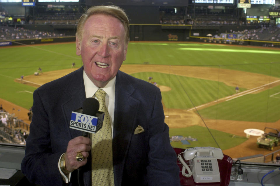 FILE - In this July 3, 2002, file photo, Los Angeles Dodgers television play-by-play announcer Vin Scully rehearses before a baseball game between the Dodgers and the Arizona Diamondbacks in Phoenix. To baseball fans, opening day is an annual rite of springthat evokes great anticipation and warm memories. This year's season was scheduled to begin Thursday, March 26, 2020, but there will be no games for a while because of the coronavirus outbreak. (AP Photo/Paul Connors, File)