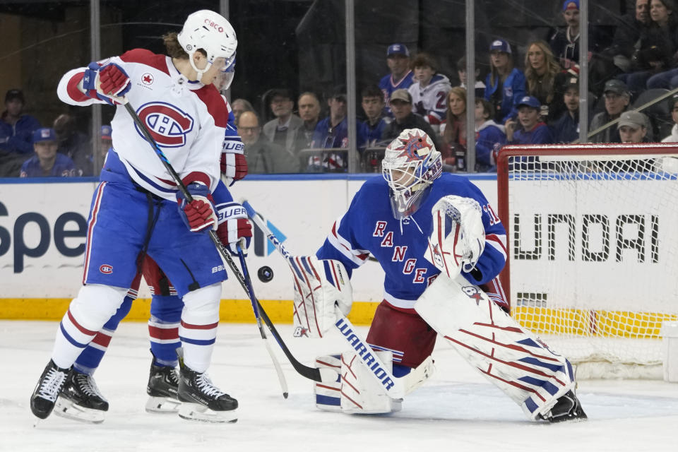 New York Rangers goaltender Igor Shesterkin, right, makes a save against Montreal Canadiens left wing Juraj Slafkovsky, front left, during the second period of an NHL hockey game, Sunday, April 7, 2024, at Madison Square Garden in New York. (AP Photo/Mary Altaffer)