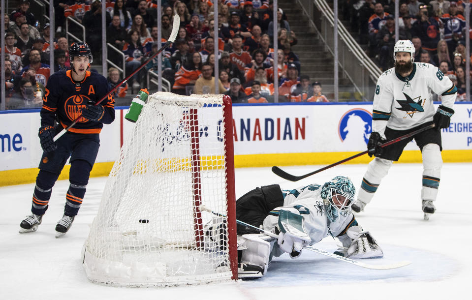 San Jose Sharks goalie James Reimer, center, is scored against as Edmonton Oilers' Ryan Nugent-Hopkins (93) watches the puck go into the net during overtime NHL hockey game action in Edmonton, Alberts, Thursday, April 28, 2022. (Jason Franson/The Canadian Press via AP)