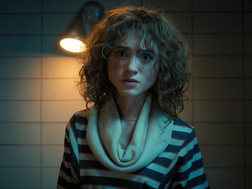 A scene from "Stranger Things" season four showing Nancy (Natalia Dyer), a teenage girl with brown curly hair.