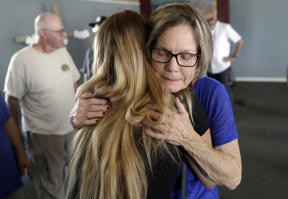 Barbara Owens, right, hugs Alexandria Johnson, whose home was damaged by an earthquake during a church service at the Christian Fellowship of Trona Sunday, July 7, 2019, in Trona, Calif. (AP Photo/Marcio Jose Sanchez)