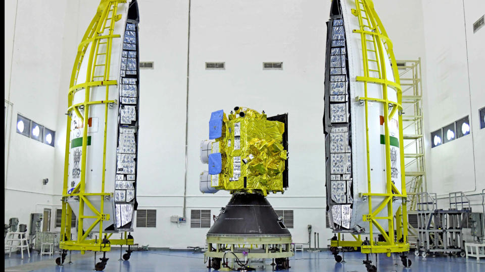 A golden satellite posed between the clamshell-like rocket fairing for India's INSAT-3DS mission.