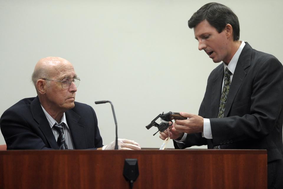 VERO BEACH - Ronald Sinclair (left), a retired Crime Scene Investigation Sergeant with the Indian River County Sheriff's Office who worked the scene of the Donna Burnell murder in 1990, inspects the murder weapon handed to him by Assistant State Attorney Ryan Butler during the resentencing Sept. 19, 2011 at the Indian River County Courthouse in Vero Beach.