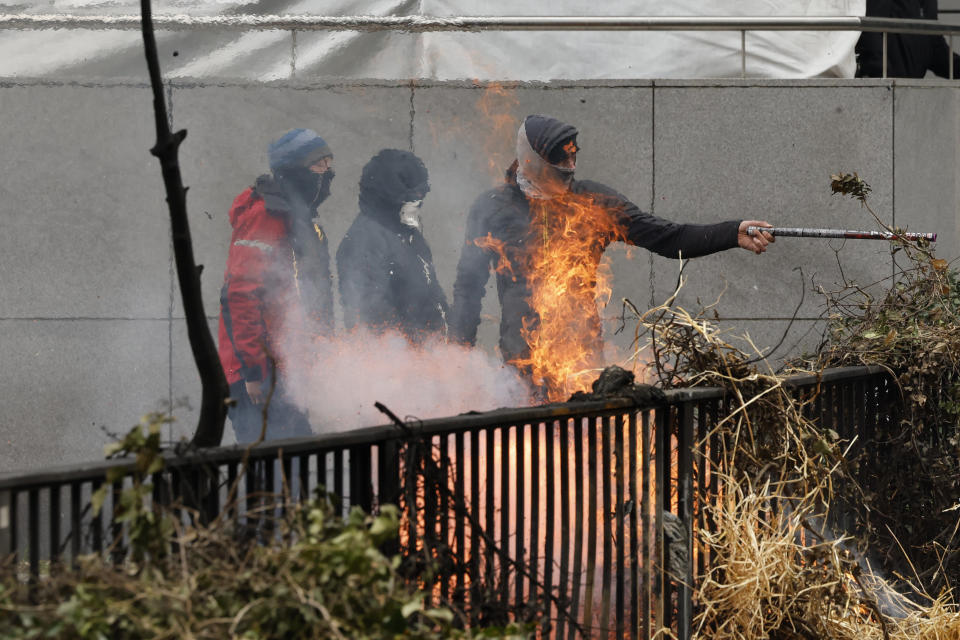 Demonstrators set fire to hay on an overpass during a demonstration of farmers near the European Council building in Brussels, Tuesday, March 26, 2024. Dozens of tractors sealed off streets close to European Union headquarters where the 27 EU farm ministers are meeting to discuss the crisis in the sector which has led to months of demonstrations across the bloc. (AP Photo/Geert Vanden Wijngaert)