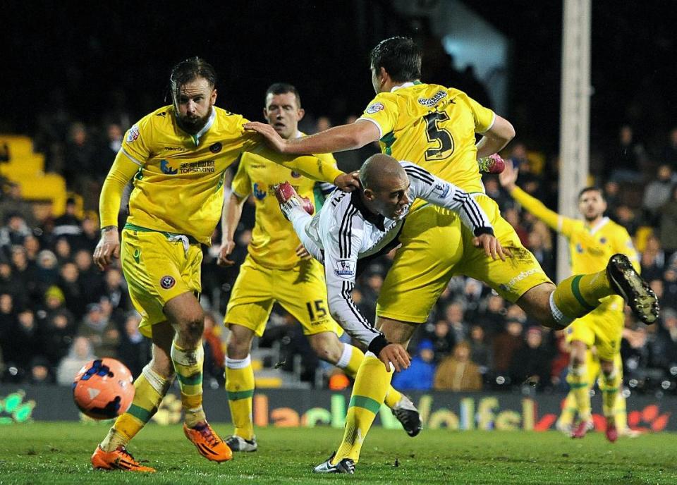 Fulham's Pajtim Kasami, centre, goes down in the penalty area under a challenge from Sheffield United's Harry Maguire, right, during their 4th round replay English FA Cup soccer match between Fulham and Sheffield United at Craven Cottage stadium in London, Tuesday, Feb. 4, 2014. (AP Photo / Andrew Matthews, PA) UNITED KINGDOM OUT - NO SALES - NO ARCHIVES