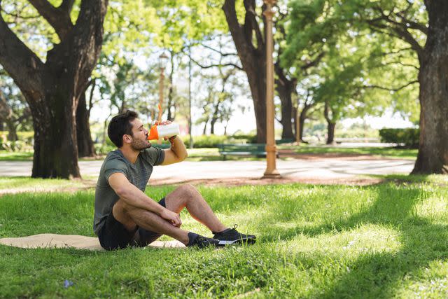 <p>Luza Studios / Getty Images</p> Taking a break from exercise with a protein shake