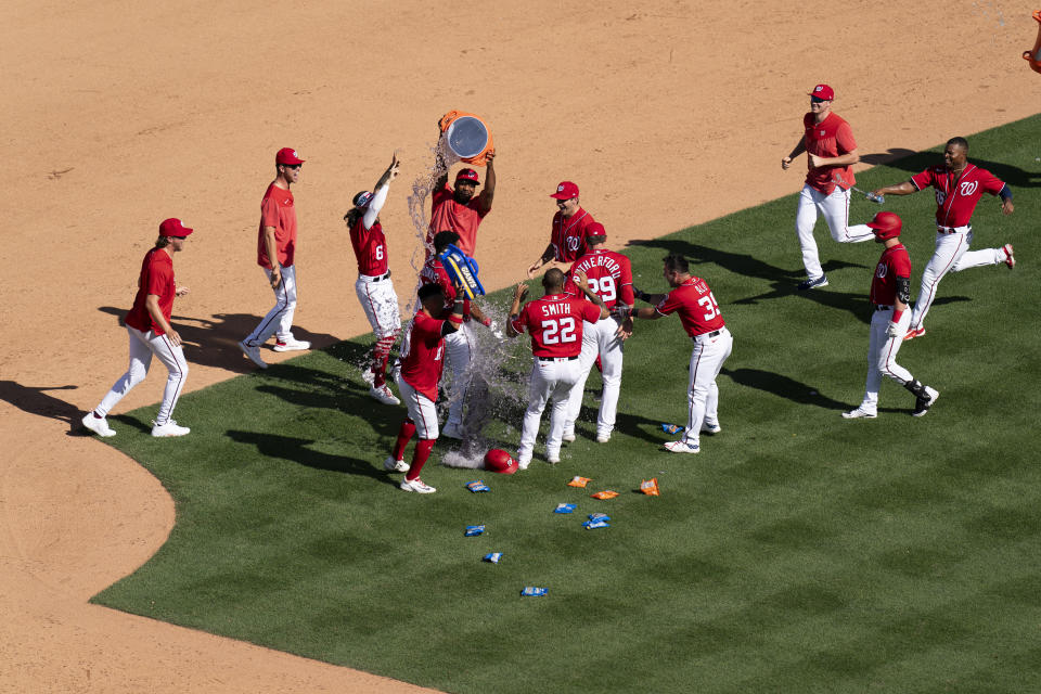 CORRECTS TO WALKOFF SINGLE NOT WALKOFF HOME RUN - The Washington Nationals celebrate after Jeter Downs hit a walkoff single during the ninth inning of a baseball game against the Oakland Athletics, Sunday, Aug. 13, 2023, in Washington. (AP Photo/Stephanie Scarbrough)