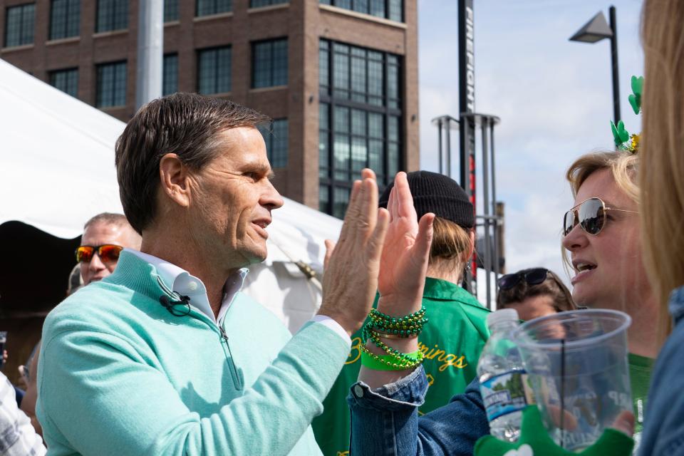 Brad Chambers, an Indiana Republican gubernatorial candidate, high fives a woman during the Indianapolis Firefighters Emerald Society’s St. Paddy’s Day Tent Party on Friday, March 15, 2024, in Indianapolis.