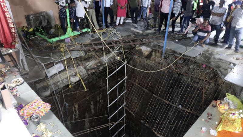 People stand around a structure built over an old temple well that collapsed Thursday as a large crowd of devotees gathered for the Ram Navami Hindu festival in Indore, India, Thursday, March 30, 2023. Up to 35 people fell into the well in the temple complex when the structure collapsed and were covered by falling debris, police Commissioner Makrand Deoskar said. At least eight were killed.