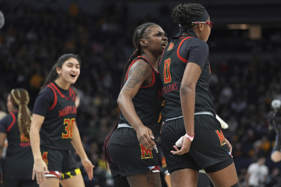 Maryland guard Bri McDaniel, center, celebrates with Ohio State guard Madison Greene (0) at the end of the first half of an NCAA college basketball game against Maryland in the quarterfinals of the Big Ten women's tournament Friday, March 8, 2024, in Minneapolis. (AP Photo/Abbie Parr)