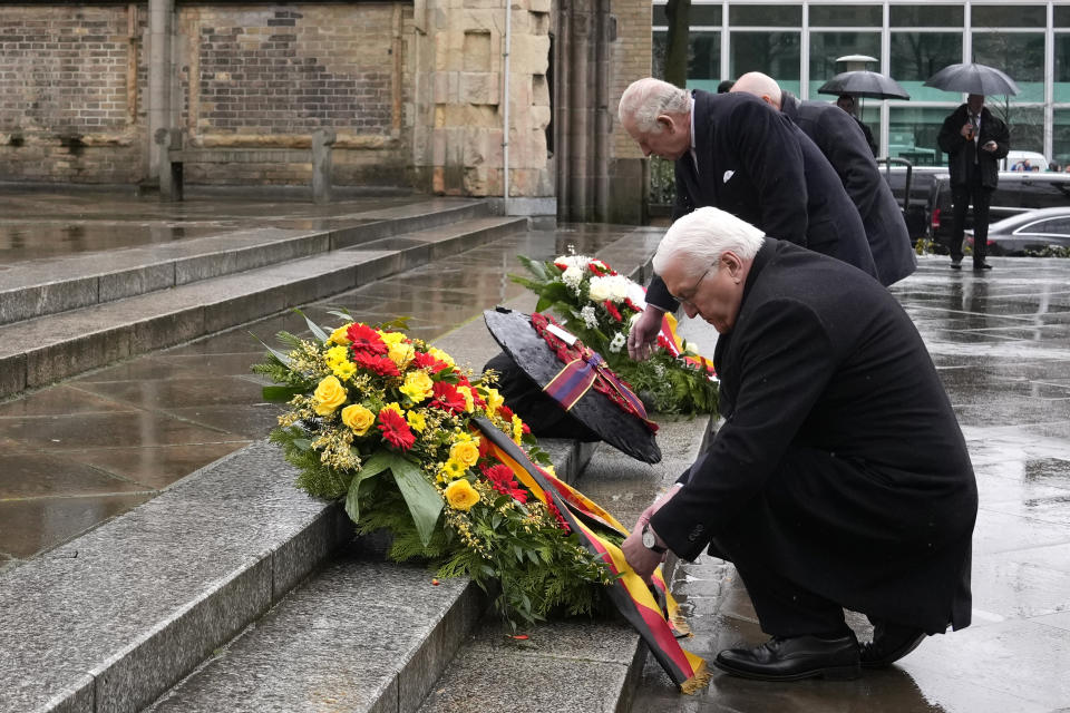 Britain's King Charles III and German President Frank-Walter Steinmeier, front, lay a wreath of flowers at St. Nikolai Memorial in Hamburg, Germany, Friday, March 31, 2023. King Charles III arrived Wednesday for a three-day official visit to Germany. (AP Photo/Matthias Schrader)