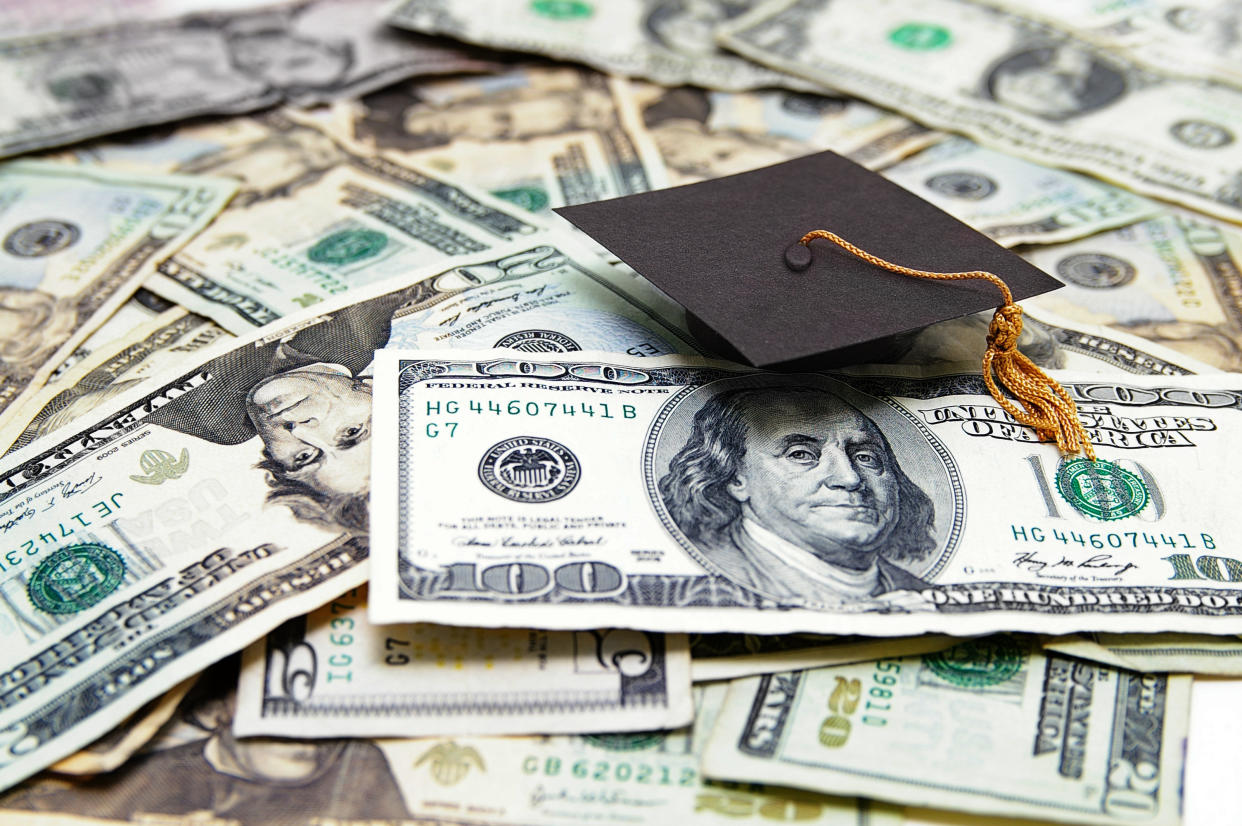  A graduation cap on top of U.S. dollars. 