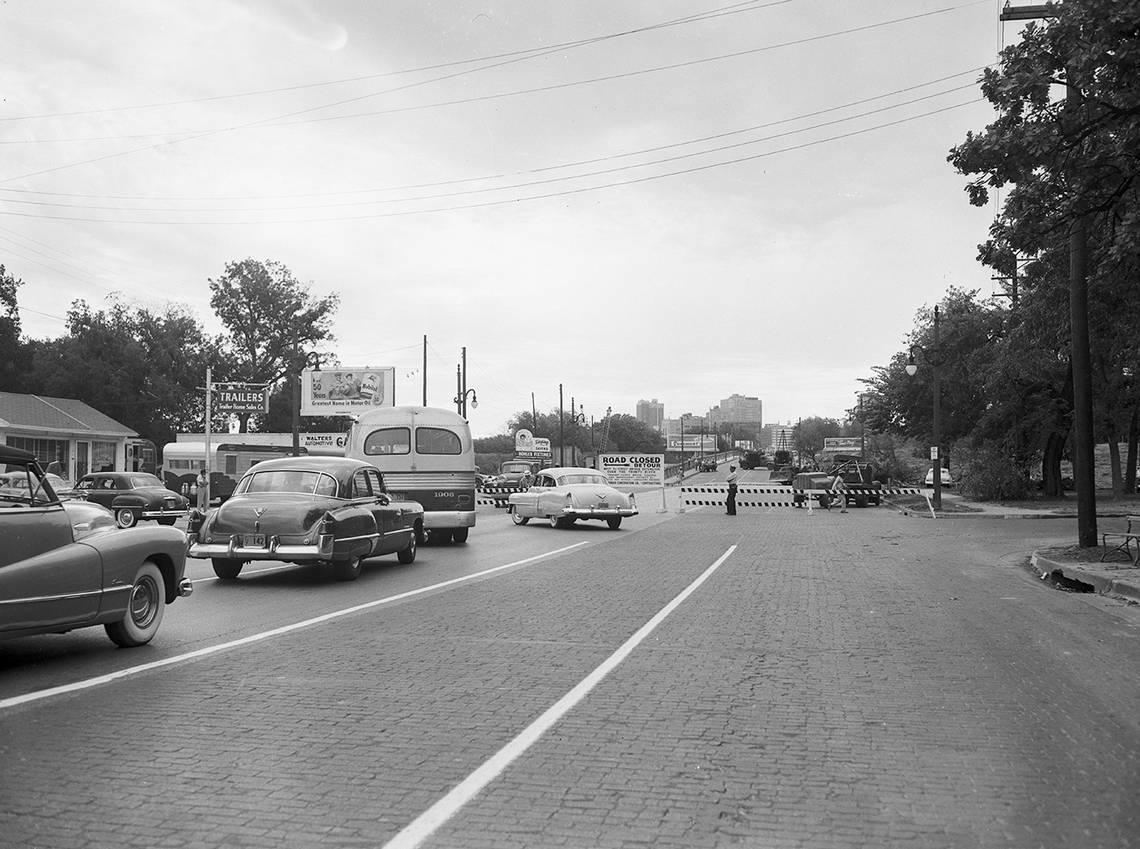 This image of a road closure on the West 7th Street bridge in 1953 shows bricks on part of the roadway, similar to those uncovered in 2022 during street improvements.