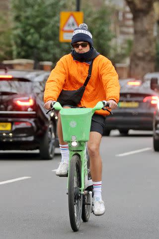 <p>MEGA</p> Harry Styles wears bright Nike jacket while on a London bike ride on his 30th birthday on Feb. 1, 2024