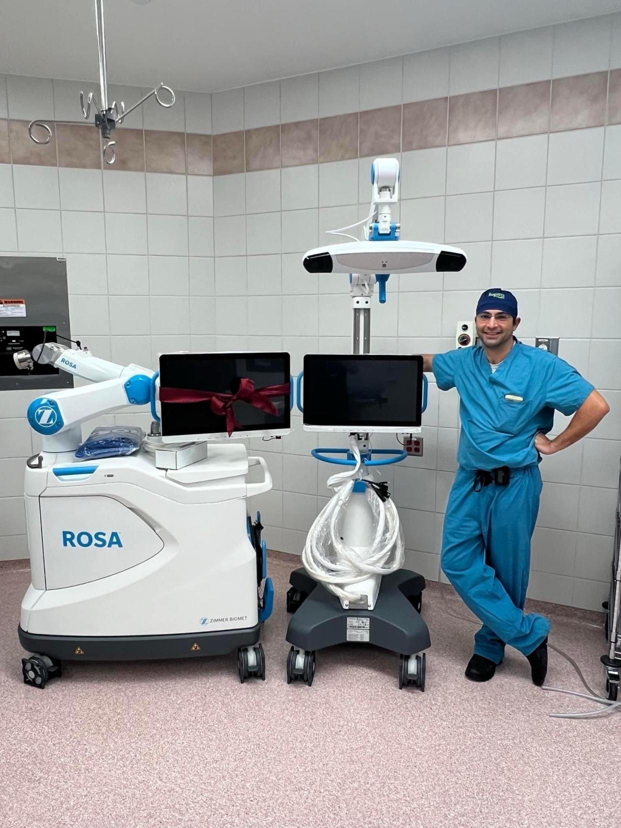 Orthopedic Surgeon Dr. G. Ryan Rieser with Shenandoah Valley Orthopedics and Sports Medicine standing by Zimmer Biomet’s ROSA Knee System at Augusta Health.