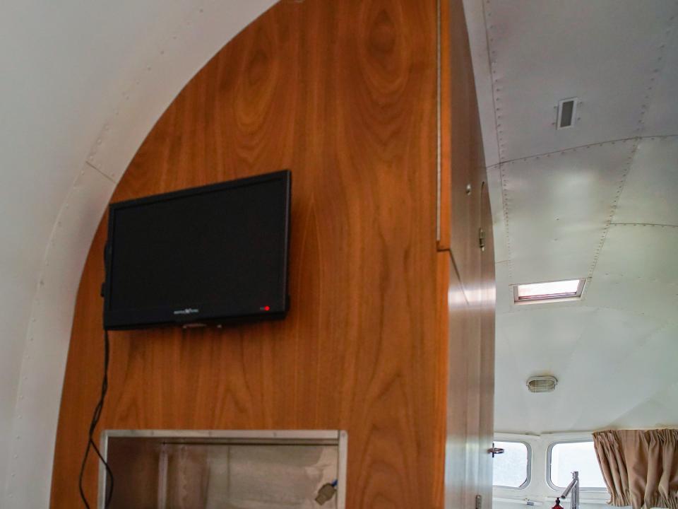 The TV above the bed in the airstream trailer.