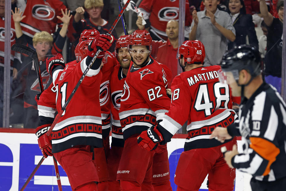 Carolina Hurricanes' Jesperi Kotkaniemi (82) turns to welcome Jordan Martinook (48) to a celebration following his goal during the second period of Game 2 of an NHL hockey Stanley Cup second-round playoff series against the New Jersey Devils in Raleigh, N.C., Friday, May 5, 2023. (AP Photo/Karl B DeBlaker)