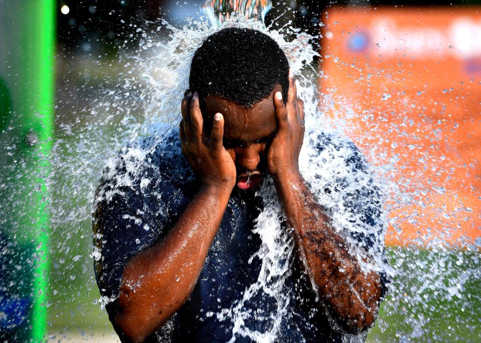 With temperatures setting a new record of 108 degrees in Abilene, Texas, on Tuesday, June 20, 2023, Aloys Baribeshya stood beneath one of the water spouts at the Nelson Park Splash Pad to cool off.