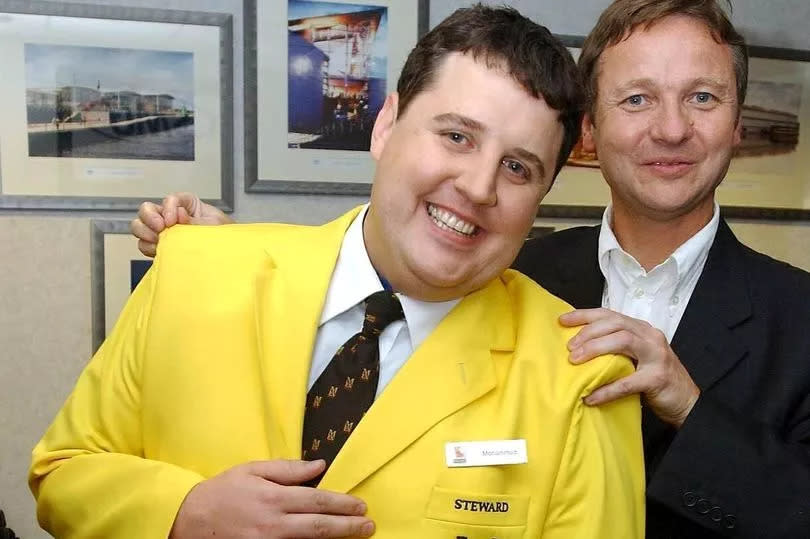 Peter Kay in a stewards jacket with John Knight from the MEN Arena in 2002