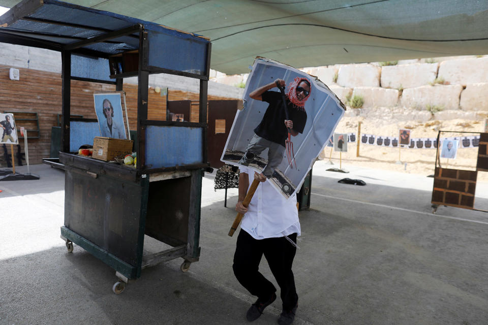 <p>A tourist carries a poster as he takes part in a two hour “boot camp” experience, at “Caliber 3 Israeli Counter Terror and Security Academy” in the Gush Etzion settlement bloc south of Jerusalem in the occupied West Bank July 13, 2017. (Photo: Nir Elias/Reuters) </p>