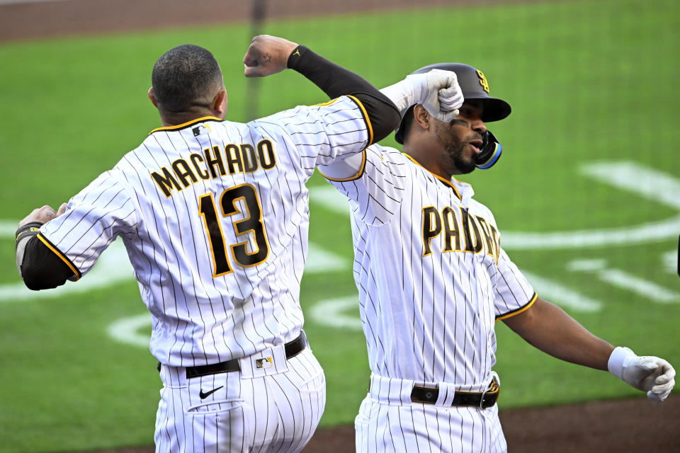 San Diego Padres' Xander Bogaerts, right, gets congratulations from Manny Machado after hitting a two-run home run against the Colorado Rockies during the first inning of a baseball game in San Diego, Saturday, April 1, 2023. (AP Photo/Alex Gallardo)