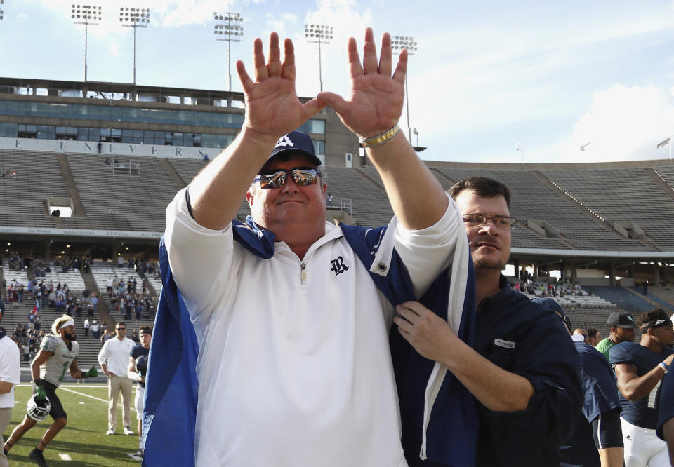 Rice head coach David Bailiff puts his hands up in the air for the Rice school song, as a fan drapes a Rice flag over his shoulders after their 30-14 loss to North Texas on Saturday. (AP)