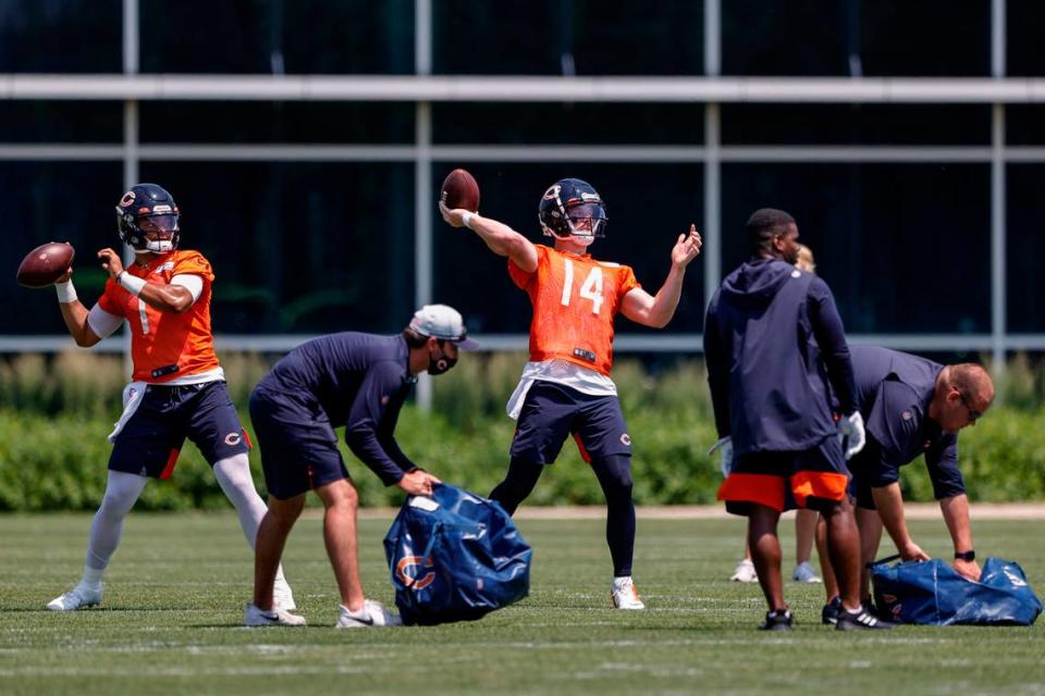 Chicago Bears quarterbacks Justin Fields (1) and Andy Dalton (14) look to pass the footballs during organized team activities at Halas Hall.