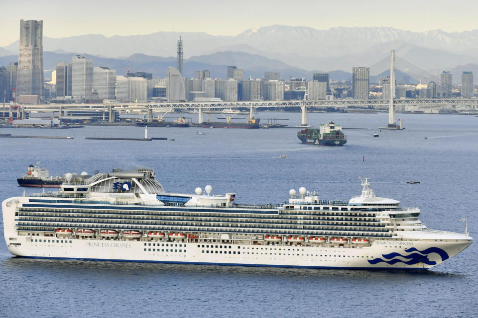 A cruise ship Diamond Princess anchors off the Yokohama Port upon arrival in Yokohama, near Tokyo Tuesday, Feb. 4, 2020. A person who was a passenger on the Japanese-operated cruise ship has tested positive for a new virus after leaving the ship in Hong Kong on Jan. 25. The ship returned to Yokohama carrying 3,000 passengers and crew members after making port calls in Vietnam, Taiwan and Okinawa. A team of quarantine officials and medical staff boarded the ship on Monday night and began medical checks of everyone on board, a health ministry official said on condition of anonymity, citing department rules. (Kyodo News via AP)