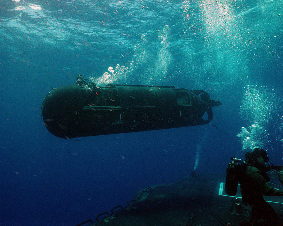 A US Navy SEAL Delivery Vehicle (SDV) moves away from a submarine onto its target as shown in the newly release coffee table top book, US Naval Special Warfare / US Navy SEALs.