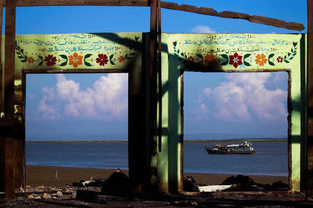FILE PHOTO: A boat is framed by the ruins of a destroyed mosque in a part of Pauktaw township that was burned in recent violence October 27, 2012. REUTERS/Soe Zeya Tun/File Photo