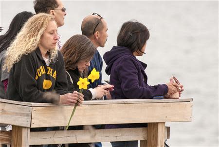 People gather on the beach for a vigil in honor of slain student Maren Sanchez in Milford, Connecticut April 25, 2014. REUTERS/Michelle McLoughlin