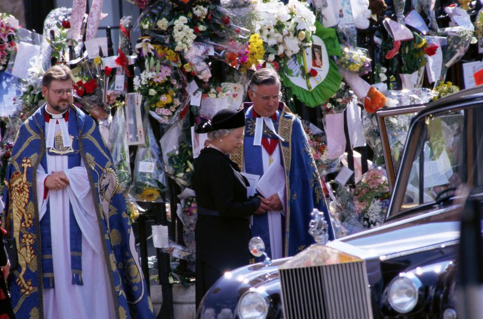 Queen Elizabeth stands with a priest at the funeral of Diana, Princess of Wales, only seven days after she was killed in an automobile accident in Paris.