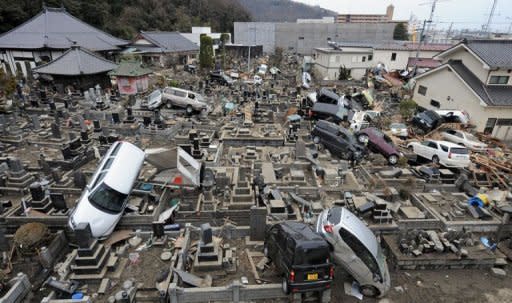 This photo taken on March 21, 2011 shows a cemetery in Ishinomaki littered with cars deposited by the tsunami. A year after whole neighbourhoods full of people were killed by the Japanese tsunami, rumours of ghosts swirl in Ishinomaki as the city struggles to come to terms with the awful tragedy