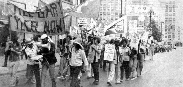 Marchers carry a banner that says "Free Gary Tyler now"