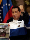 Chávez muestra de una copia de un periódico local en el aeropuerto de Maiquetía, en Caracas, Venezuela, el 4 de julio de 2011. AP Photo/Ismael Francisco, Prensa Latina