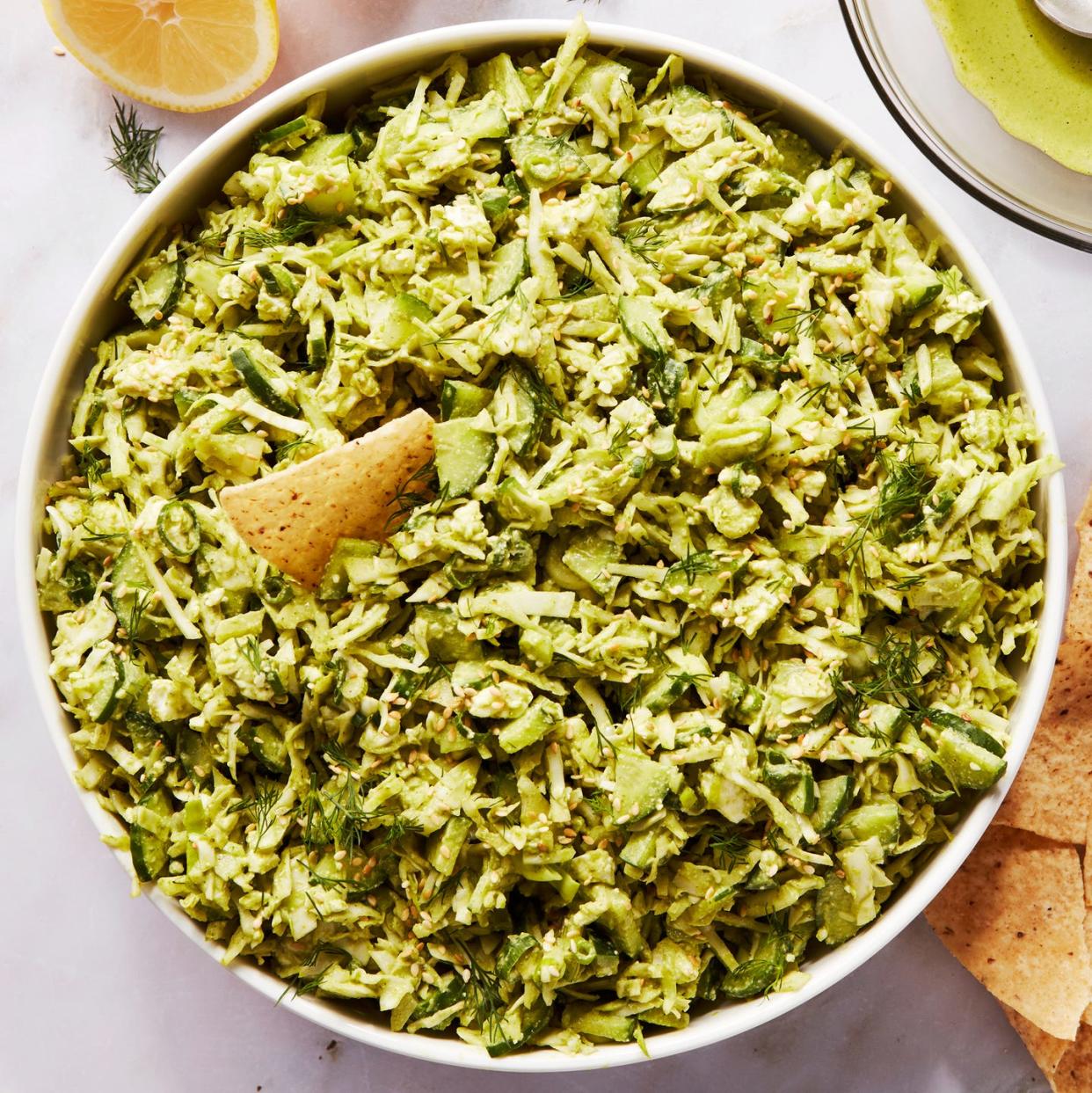 finely chopped green vegetables in a bowl with tortilla chips