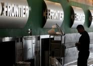 FILE PHOTO: Workers at the Frontier Airlines ticket counter at the Denver International Airport