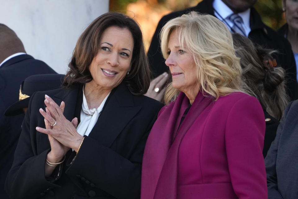 Vice President Kamala Harris talks with first lady Jill Biden before President Joe Biden speaks at the National Veterans Day Observance at the Memorial Amphitheater at Arlington National Cemetery in Arlington, Va., Saturday, Nov. 11, 2023. (AP Photo/Andrew Harnik)