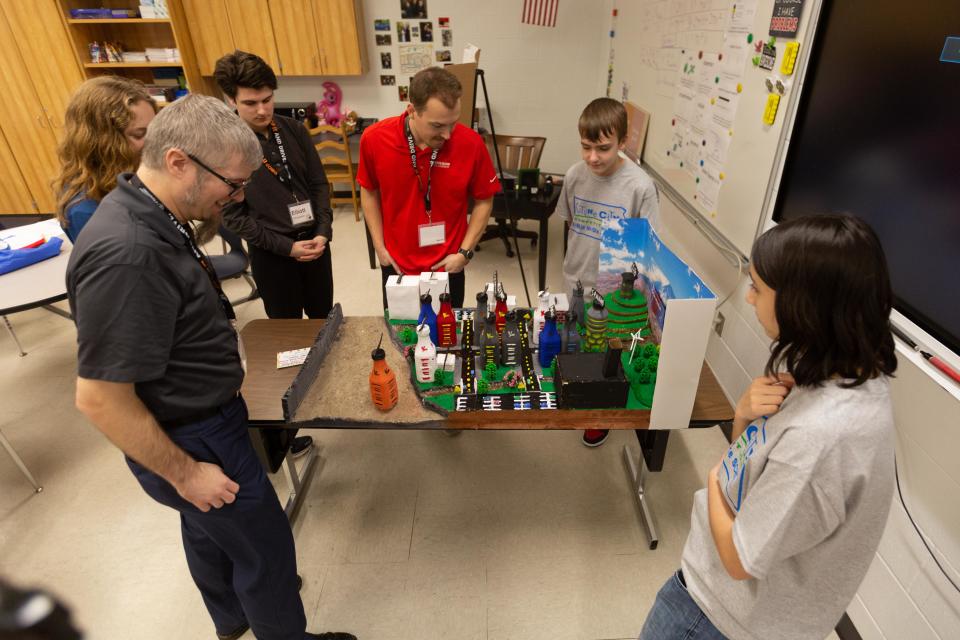 A panel of judges evaluates Storm Point, Japan — a mockup of a potential, sustainable city that a team of Seaman Middle School students developed.