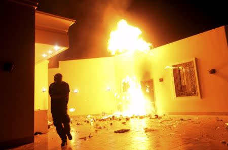 The U.S. Consulate in Benghazi is seen in flames during a protest by an armed group said to have been protesting a film being produced in the United States, in this September 11, 2012 file photo. Partly burned and still abandoned, the high-walled villas that once housed the U.S. consulate compound in the Libyan city of Benghazi now sit on a frontline of a nation at war with itself. Three years after militants killed U.S. ambassador Christopher Stevens and three other Americans in an attack on the facility, Benghazi is back in U.S. news headlines as White House contender and former secretary of state Hillary Clinton faces a Congressional hearing on the incident on October 22, 2015. For Libyans and Benghazi, though, the war never really disappeared. After their democratic hopes were kindled following the 2011 revolt against Muammar Gaddafi, Libya has steadily spiralled into chaos among a myriad of armed factions. To match story LIBYA-SECURITY/BENGHAZI REUTERS/Esam Al-Fetori/Files