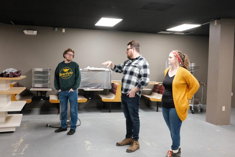 Starflyer Brewing Co. cofounder Andrew Archer, center, is standing where he is planning the bar to be. His brother-in-law Ethan Comfort, left, and his wife, Bailey Archer, are also cofounders.