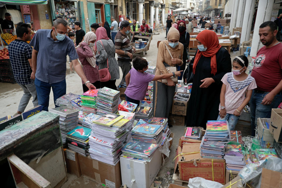 People shop for school supplies in preparation for the new school year, in Baghdad, Iraq, Sunday, Oct. 31, 2021. Across Iraq, students returned to classrooms Monday for the first time in a year and a half – a stoppage caused by the coronavirus pandemic - amid overcrowding and confusion about COVID-19 safety measures. (AP Photo/Khalid Mohammed)